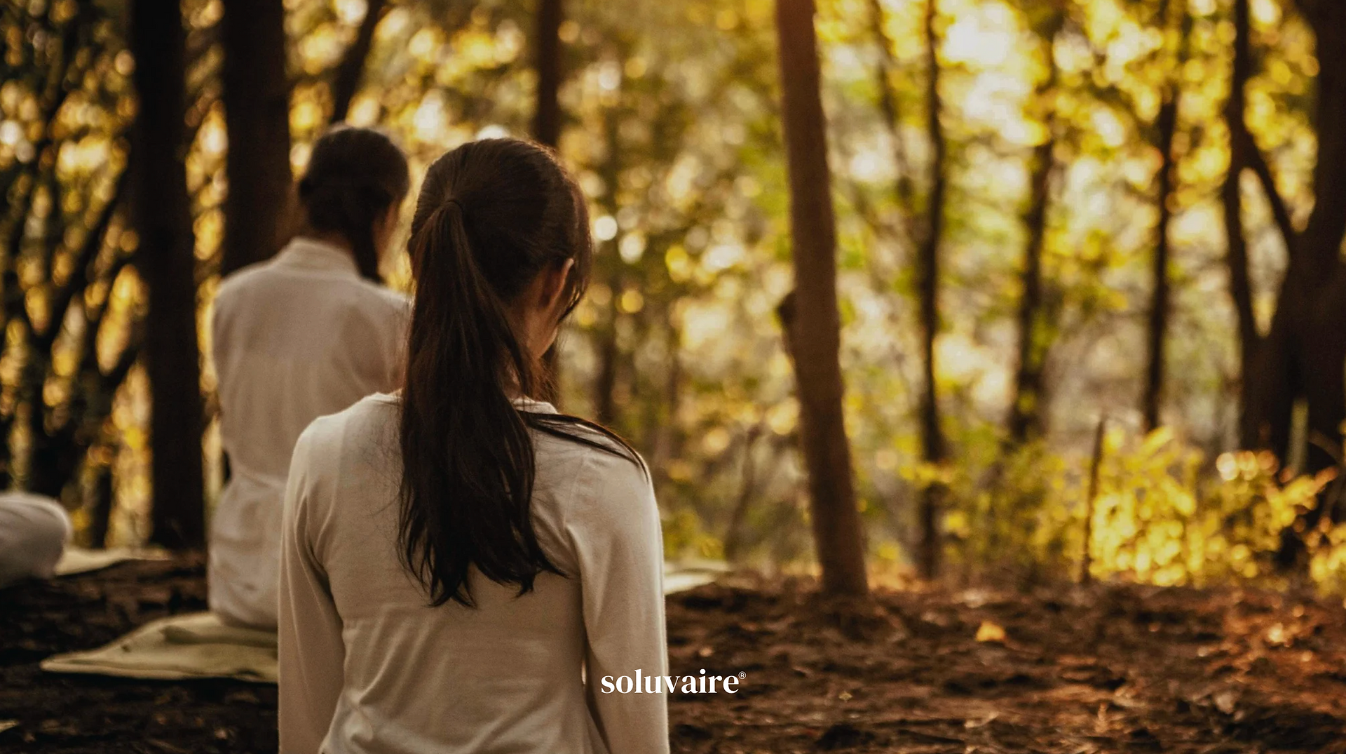 eine Gruppe von Menschen praktizieren soluviare Breathwork in einem wald.
