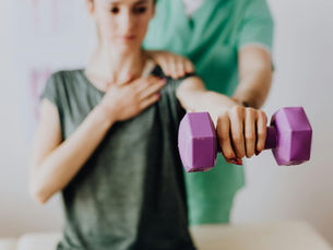 Physiotherapist guiding a patient through shoulder rehabilitation exercises to improve strength and mobility.