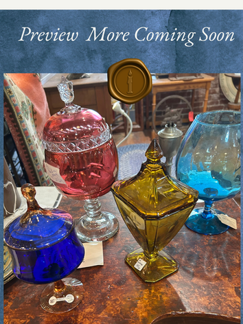 A close-up image of an arrangement of four ornate pieces of glassware: a blue circular vase, a red oval vase, a square golden yellow vase, and an aqua blue whiskey glass, The picture is "attached" to a velvety light blue background with a gold wax seal, and it reads "Preview, More Coming Soon"