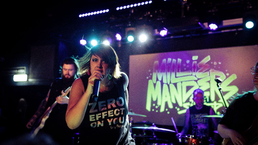 Singer on left side of photo, holding microphone