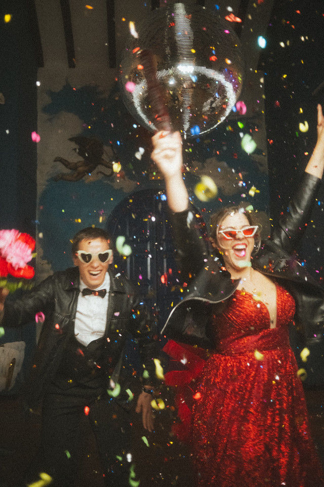 A married couple celebrating in confetti under a disco ball