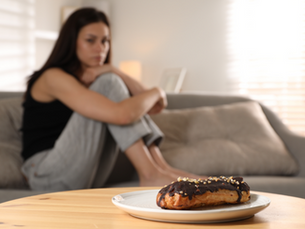 A woman sitting and looking at a food on a plate
