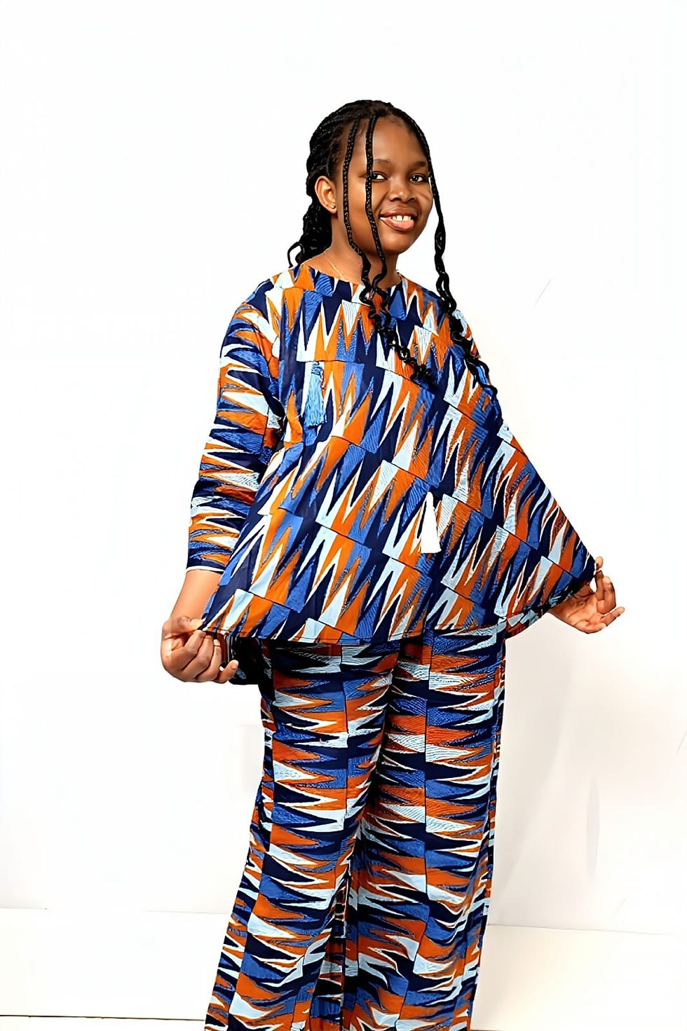 Young girl smiling, wearing abstract blue orange white print two-piece outfit.
