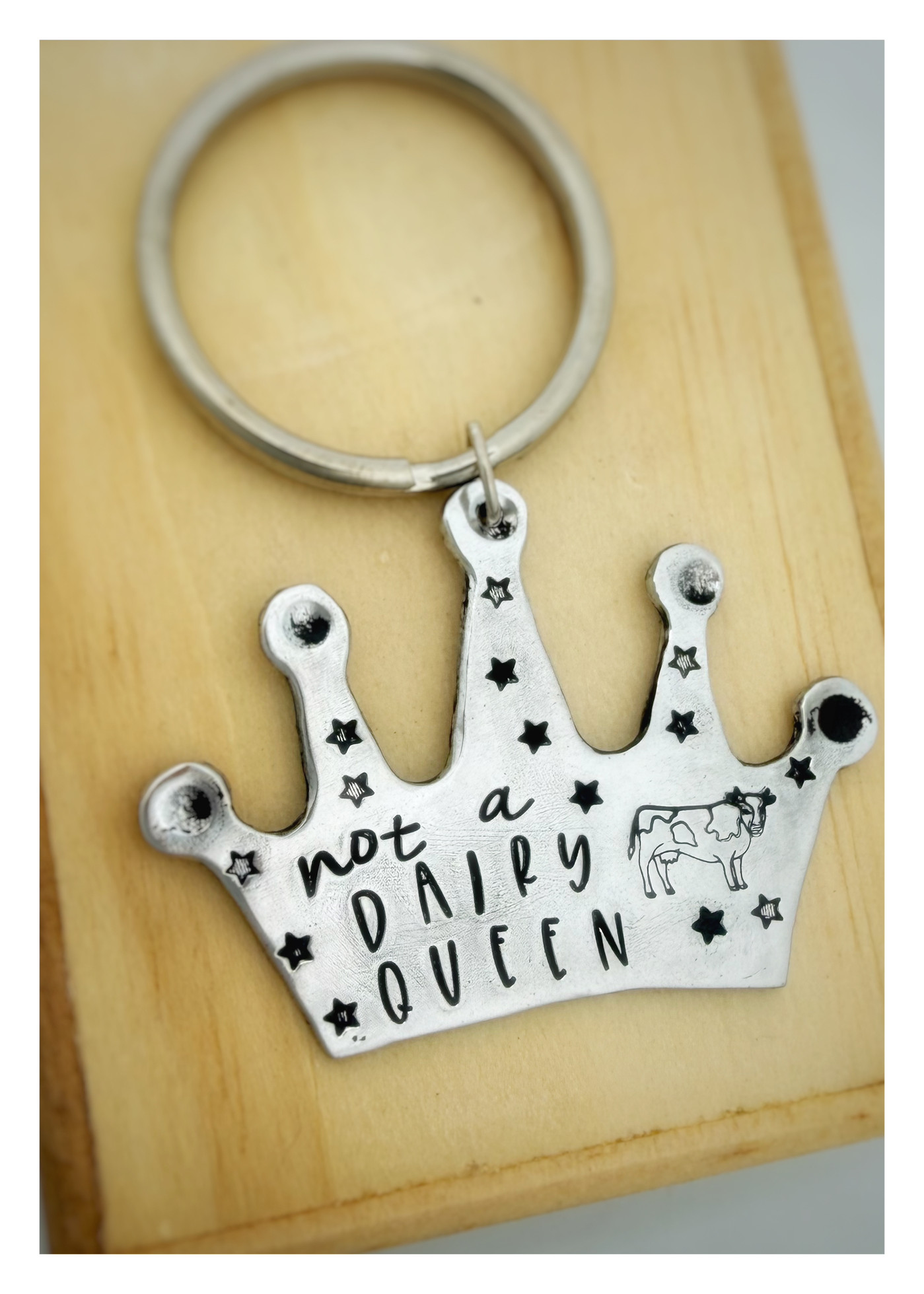 A shiny recycled aluminum crown keychain showing artisan details