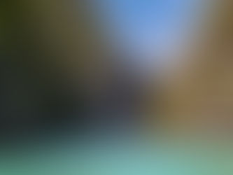 Massive limestone karst formations rising sharply from the clear blue waters of an El Nido lagoon in Palawan.