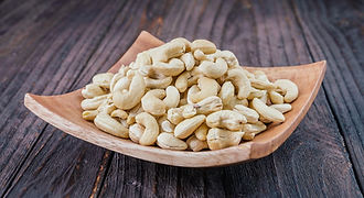 A pile of high-quality Palawan cashews or kasuy served in a rustic wooden bowl, showcasing the famous local nut snack that travelers love to take home as gifts.