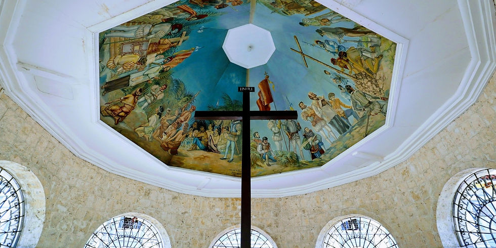 A large wooden cross stands beneath a painted dome ceiling depicting historic Spanish explorers inside Magellan's Cross Pavilion in Cebu.