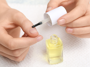 Woman applying cuticle oil to her nail beds