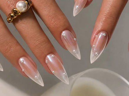 Long stiletto bridal nail designs with sheer pink chrome polish, translucent French tips, and delicate pearl accents.