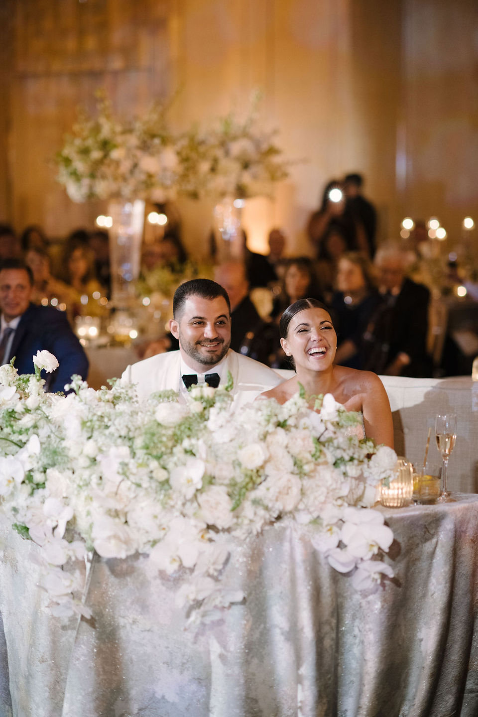 Melissa Davis Designs bride and groom smiling at sweetheart table during wedding speeches