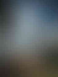 A tranquil sunset over Lake Kivu as seen from Tchegera Island, with the sun casting a golden glow on the water.