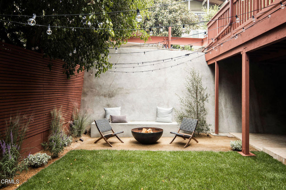 a backyard with a couch and chairs and a fire pit