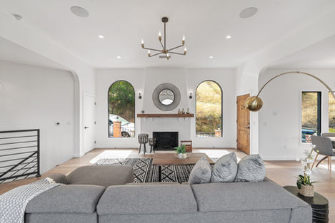 a living room with a fireplace and arched windows