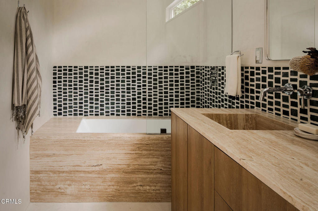 a bathroom with black and white tiles and a sink