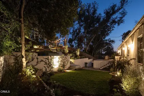 the backyard of a house is lit up at night