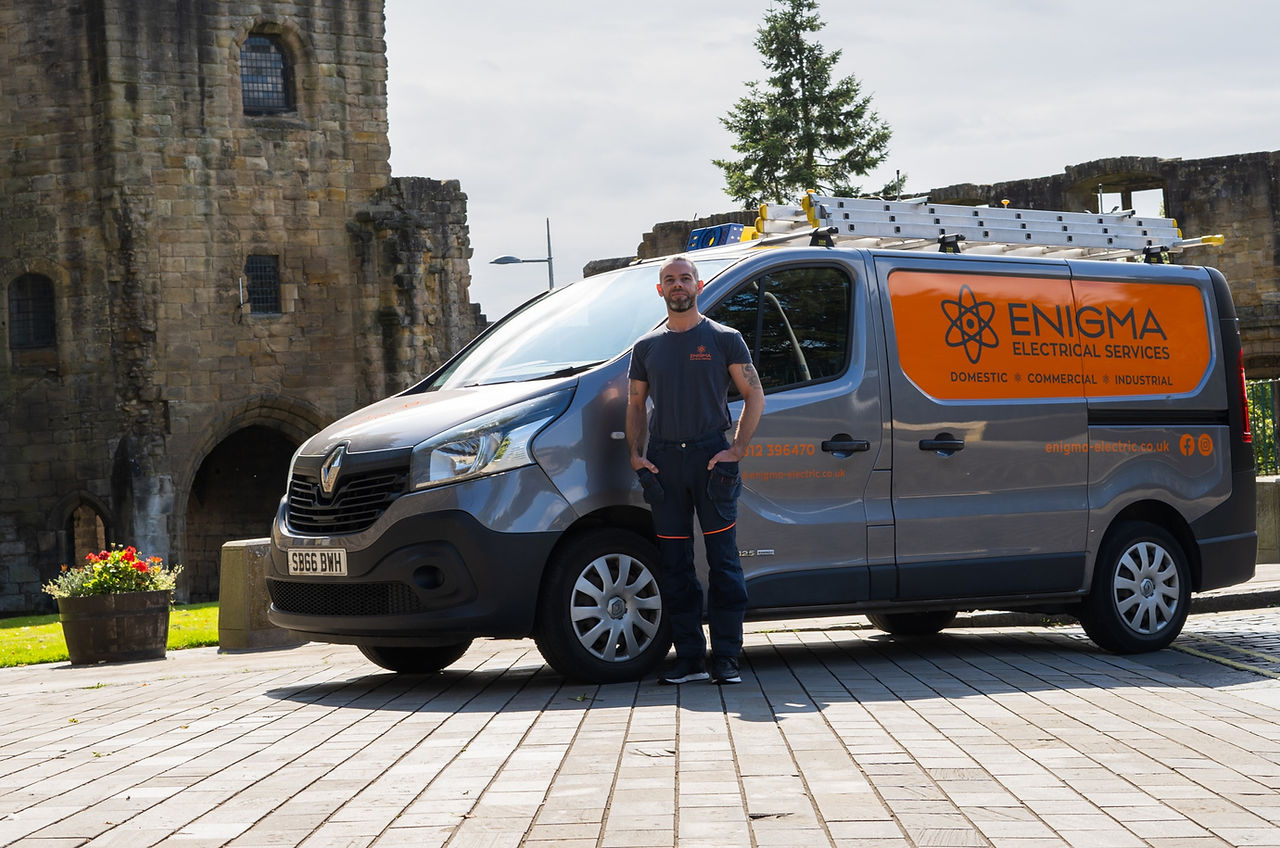 Enigma Owner Liam Carberry standing infront of Enigma Electrical Services Van at Dunfermline Abbey in Fife Scotland. Local Electrician. Owner and CEO.