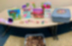 Colorful worm and compost books displayed on a table with pipe-cleaner worms and a blue compost bin.