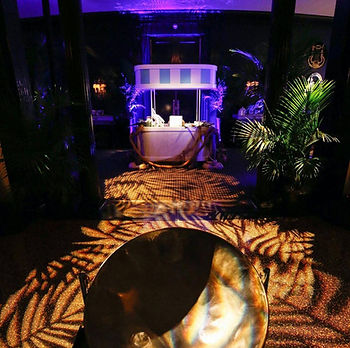 TROPICAL THEME PARTY CHICAGO. This event design was created by Cavalier and Company, and Chicago based design firm specializing in interior design, event and wedding planning and design, experiential brand marketing, and seasonal decor. It featured custom fabrication, lighting, live entertainment, rental furniture, custom graphics, and floral designs. This surprise 50th birthday was planned at the Casino Club in Downtown Chicago.
