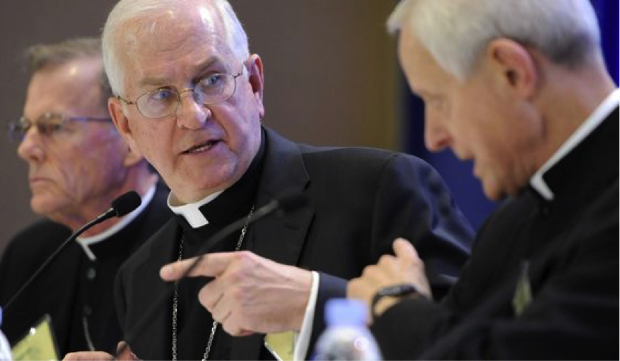 Three pale-skinned white-haired men in clerical collars—white bands beneath black shirts and suit jackets—gesture while they talk to each other in this close up shot. They are, from left, Bishop John C. Wester of Salt Lake City, Archbishop Joseph E. Kurtz of Louisville, KY and president of the US Conference of Catholic Bishops, and Cardinal Donald W. Wuerl, Archbishop of Washington. The picture was taken during the conference’s annual fall meeting in Baltimore on Monday, November 10, 2014. IMAGE CREDIT: AP Photo/Steve Ruark.