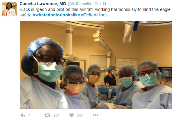 In this screenshot of a tweet by Camelia Lawrence, MD, we see six women scrubbed in and fully garbed in surgical gear. The patient is not visible (as is only correct).  Two of the women have dark brown skin. The hashtag is #whatadoctorlookslike.