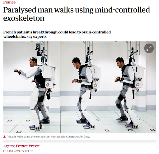 A screenshot from a Guardian article shows the headline "Paralysed man walks using mind-controlled exoskeleton: French patient's breakthrough could lead to brain-controlled wheelchairs, say experts." The date is Friday Oct 4 2019. The byline is Agence France-Presse. There are three images showing a man strapped into a bulky white exoskeleton that holds his legs, his torso, and his arms in place. Each part of his body is only enclosed on one side (the back of his arms, the back of his legs, his back). The device appears to be attached loosely to the ceiling on a track, presumably to prevent falling. Each of three shots shows the man at a different point in the room, in a different walking body position.