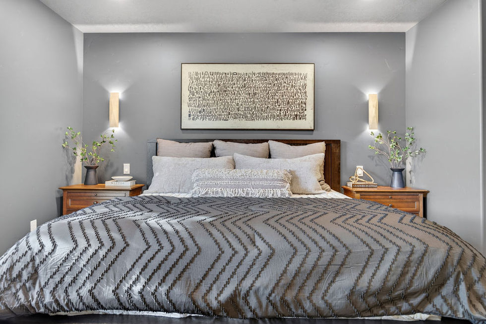 Elegant bedroom with gray bedding and wall art.