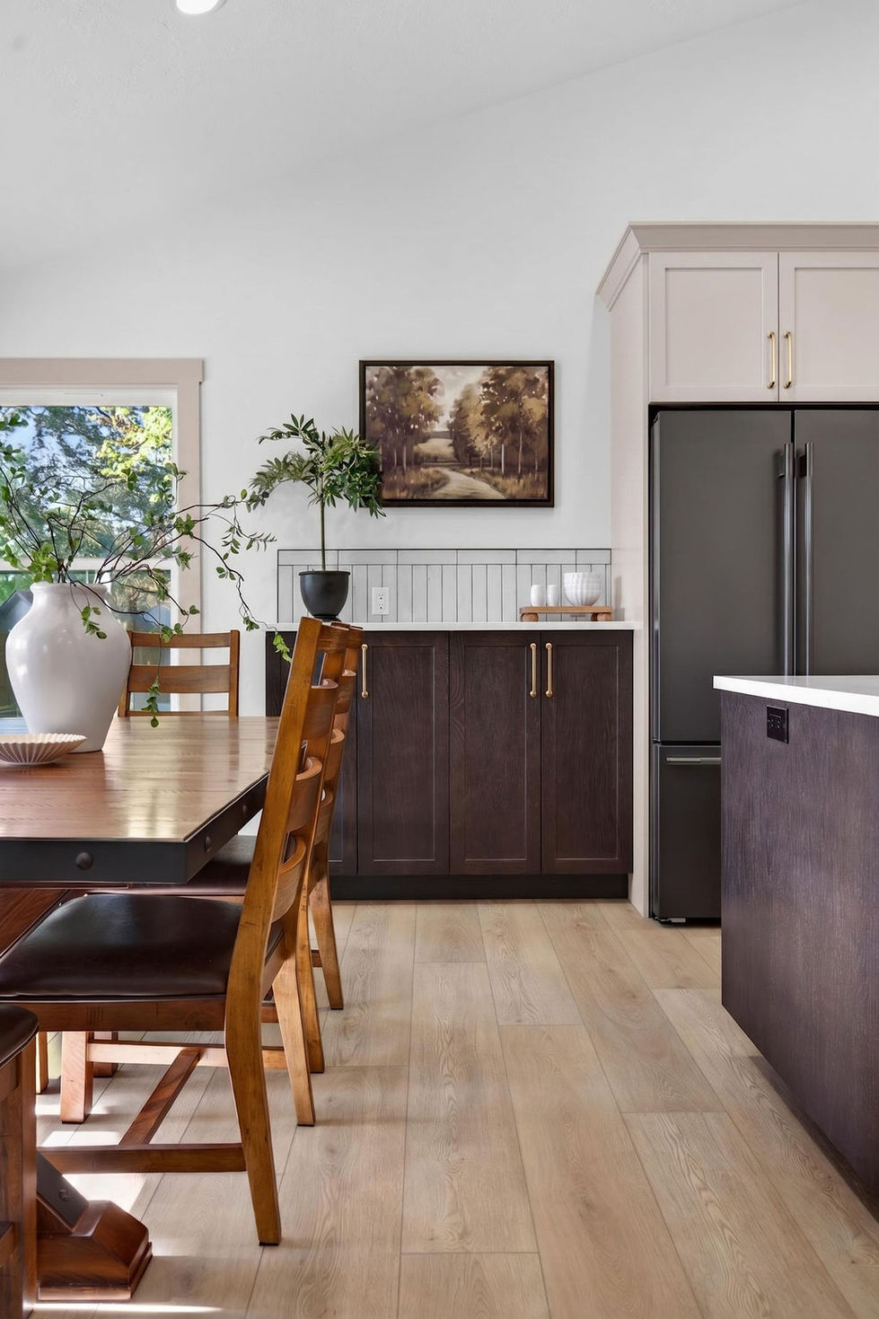 Modern kitchen with wooden furniture and black appliances.