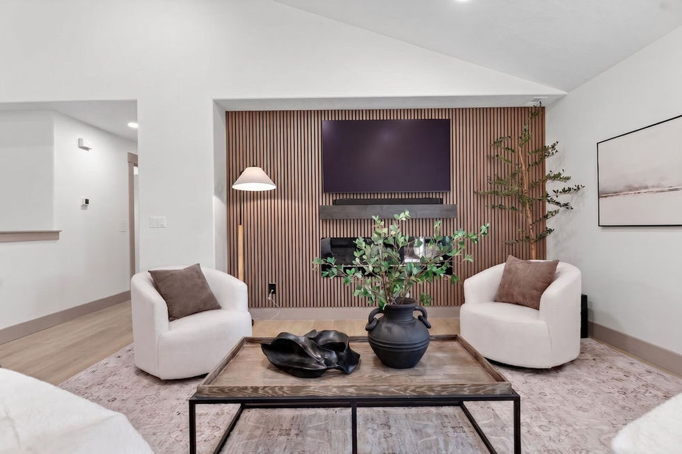 Modern living room with TV, chairs, and coffee table.