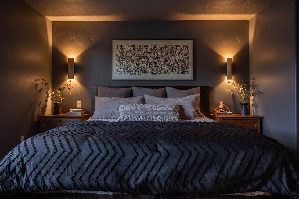 Cozy bedroom with dark bedding and warm lighting.