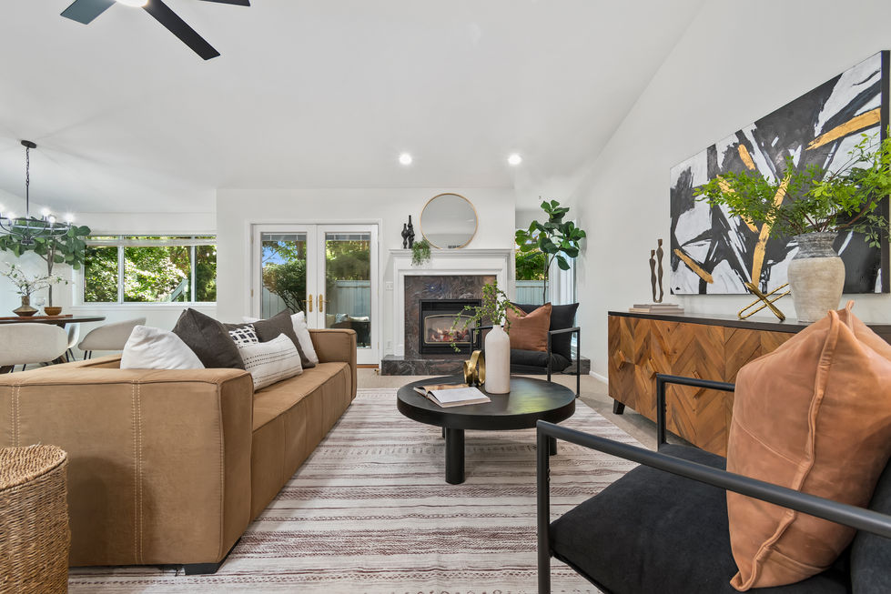a living room with a brown couch and a black chair