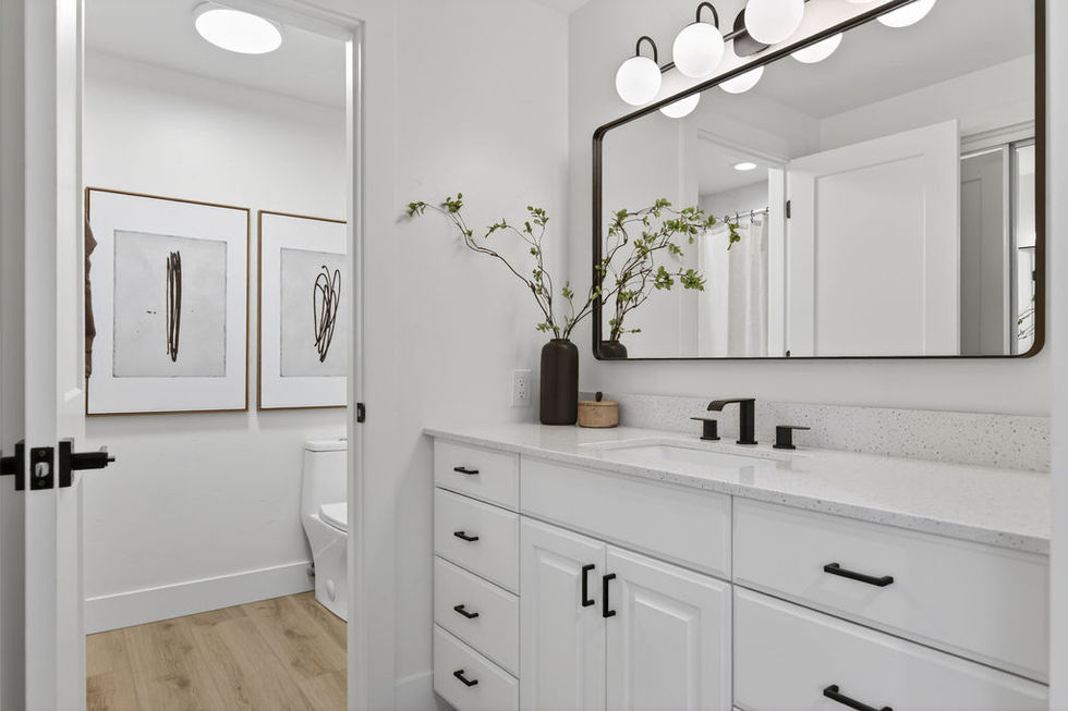 Modern bathroom with white cabinets and large mirror.