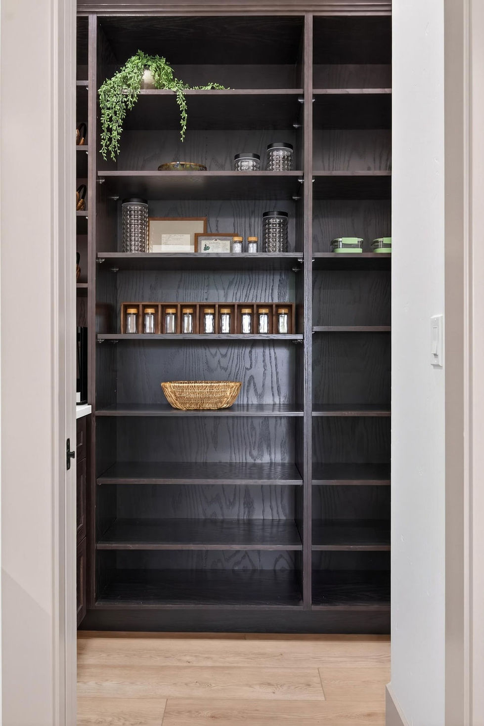 Small, organized pantry with shelves and storage baskets.
