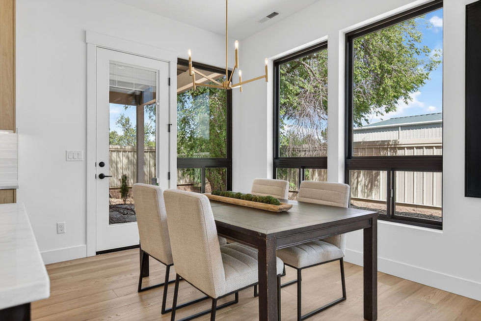 Modern dining room with large windows and elegant chandelier.