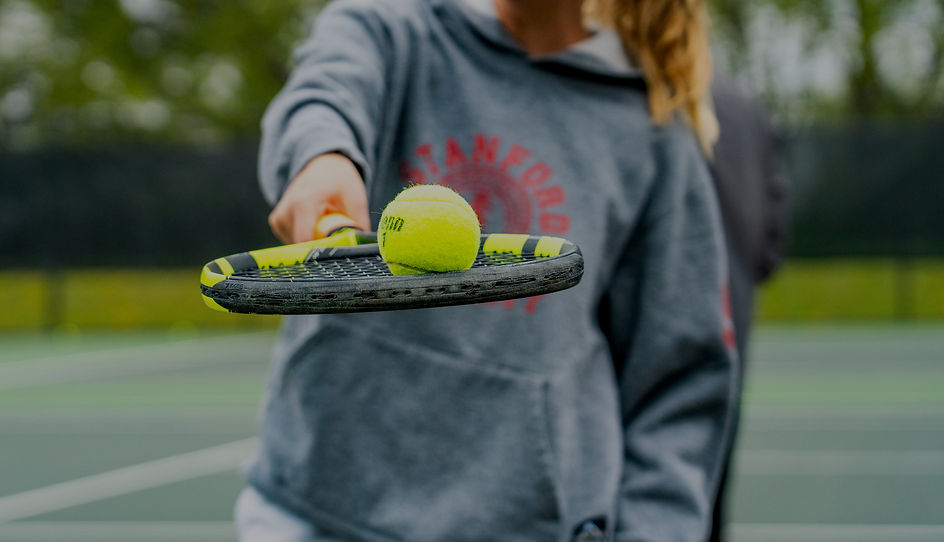 Girl balancing a tennis ball on her racket