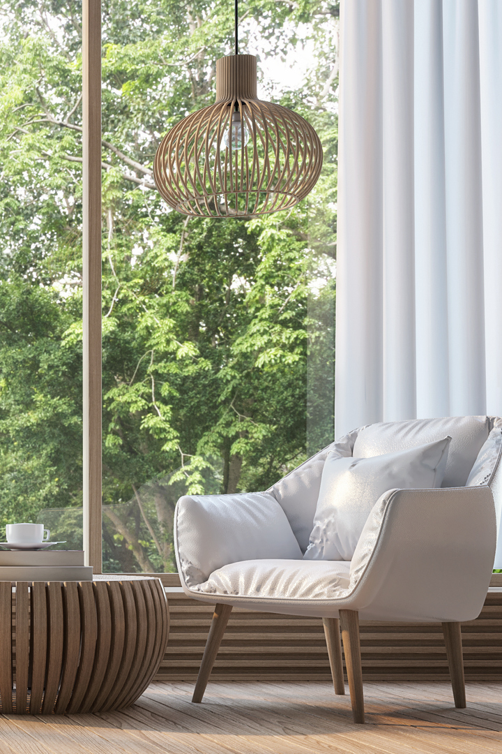 Modern armchair by a window with a woven pendant lamp.
