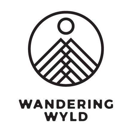 Wandering Wyld logo with mountain and sun in a circle