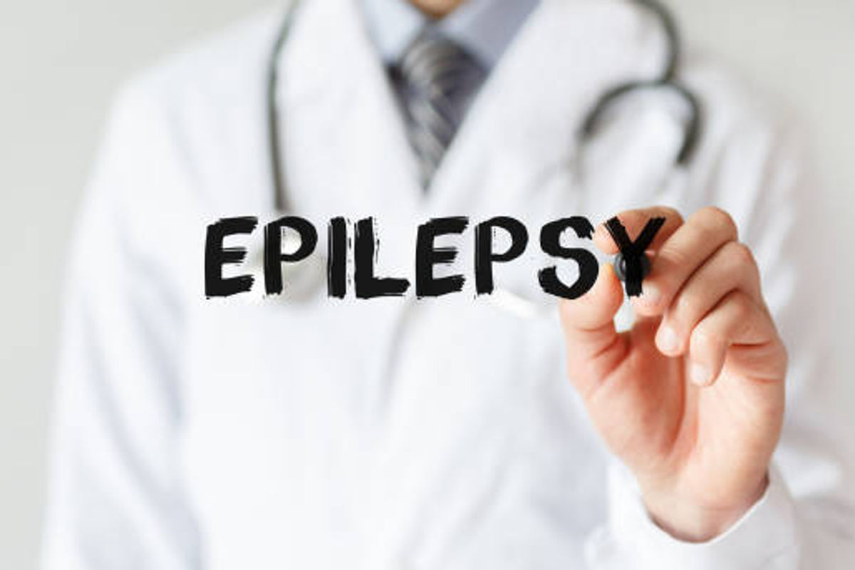 Scritta "Epilepsy" in nero con un medico sullo sfondo