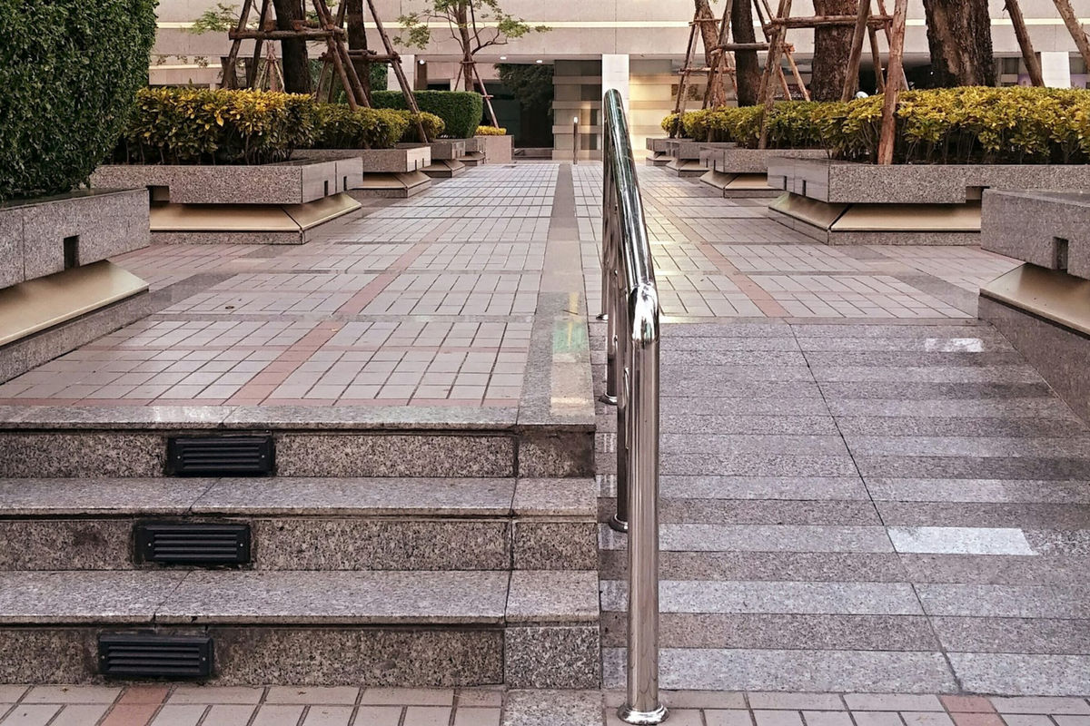 Foto generica di esempio di una rampa di scale affiancate da rampa per persone con disabilità motorie