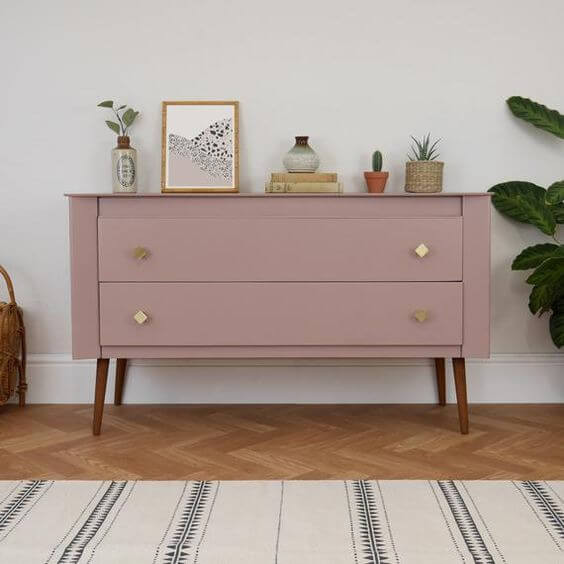 upcycled sideboard in dusty pink with brass hardware. Midcentury walnut legs. Styled with cacti, art, books and pots.