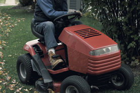 Tonte mécanique de jardin avec tondeuse autoportée sur pelouse étendue.