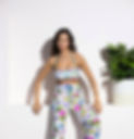 Model wearing flower outfit two-piece leaning next to plant