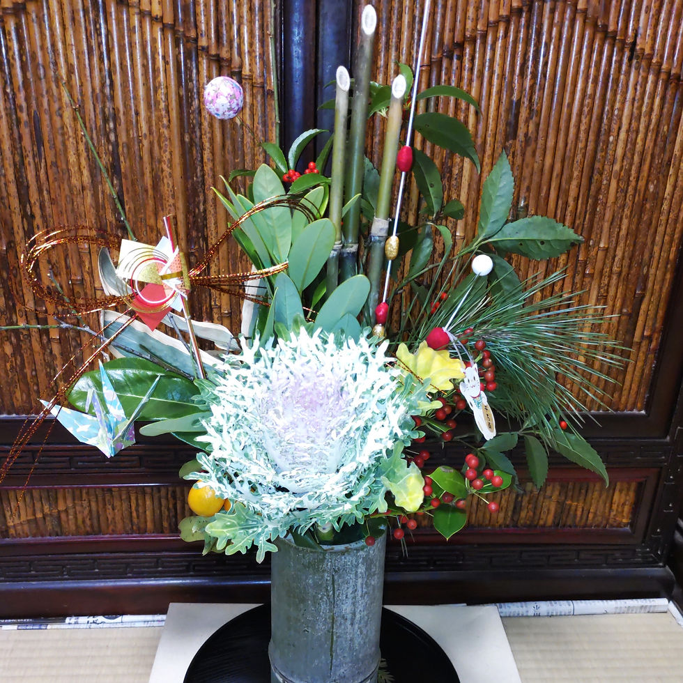 正月の生け花です。竹の花器に、竹、松、葉牡丹を生けて、折鶴、水引などを添えて。