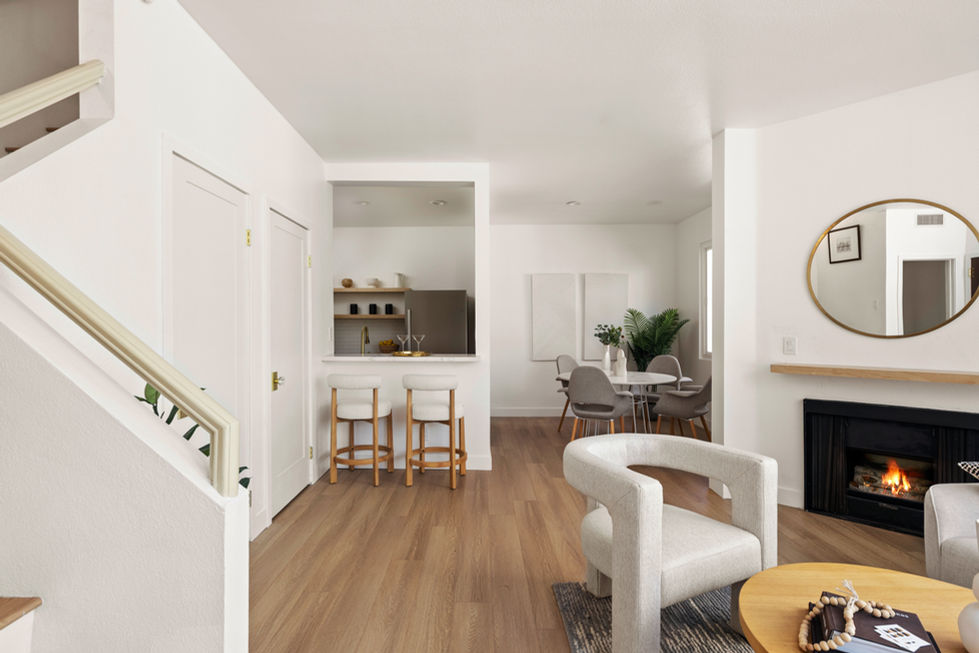 Open-concept living and dining area showcasing patched drywall, repaired ceiling, even wall texture, and fresh interior paint on walls, trims, and doors.