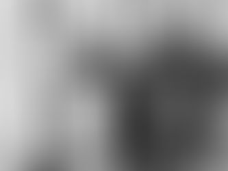 Man lifting weights while a gym coach assists