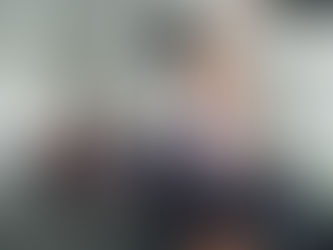 A woman at Peak Fitness and Motion lifting a weight over her head while onlookers are impressed