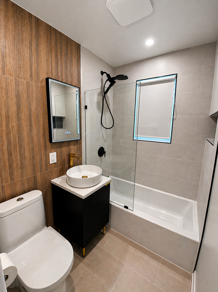 Brantford bathroom renovation contractor modern small bathroom remodel with wood accent wall, light vanity, vessel sink, glass shower, and black fixtures