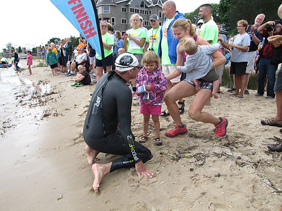 Family warmly greets swimmer at Mighty Mac Swim finish