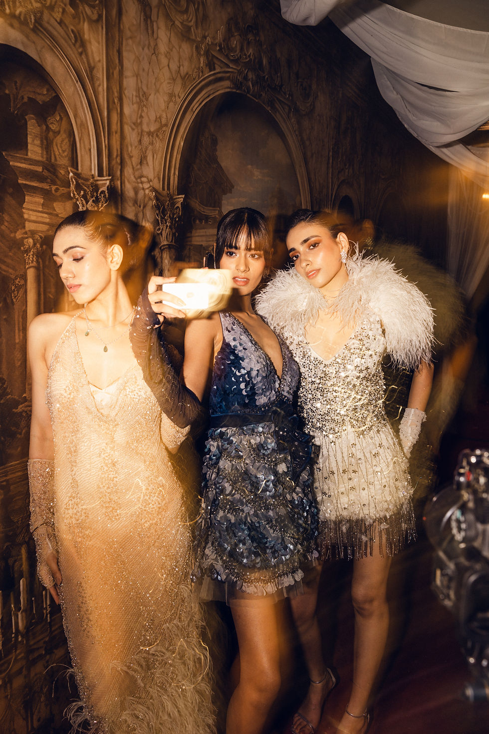 Not So Serious by Pallavi Mohan’s Wilted Roses & Champagne looks to the hours after the formalities, bringing sculptural cocktail minis, embellished eveningwear and dramatic gowns into the wedding-season wardrobe. Sheer tulle, liquid satin, feathers, sequins and three-dimensional floral detailing appear across a palette of champagne gold, antique ivory, blush rose, deep berry and moonlit silver, giving the collection its deliberately romantic yet slightly undone character. Photo Credit: Not So Serious by Pallavi Mohan