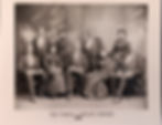 African American choir wearing formal dresses and suits.