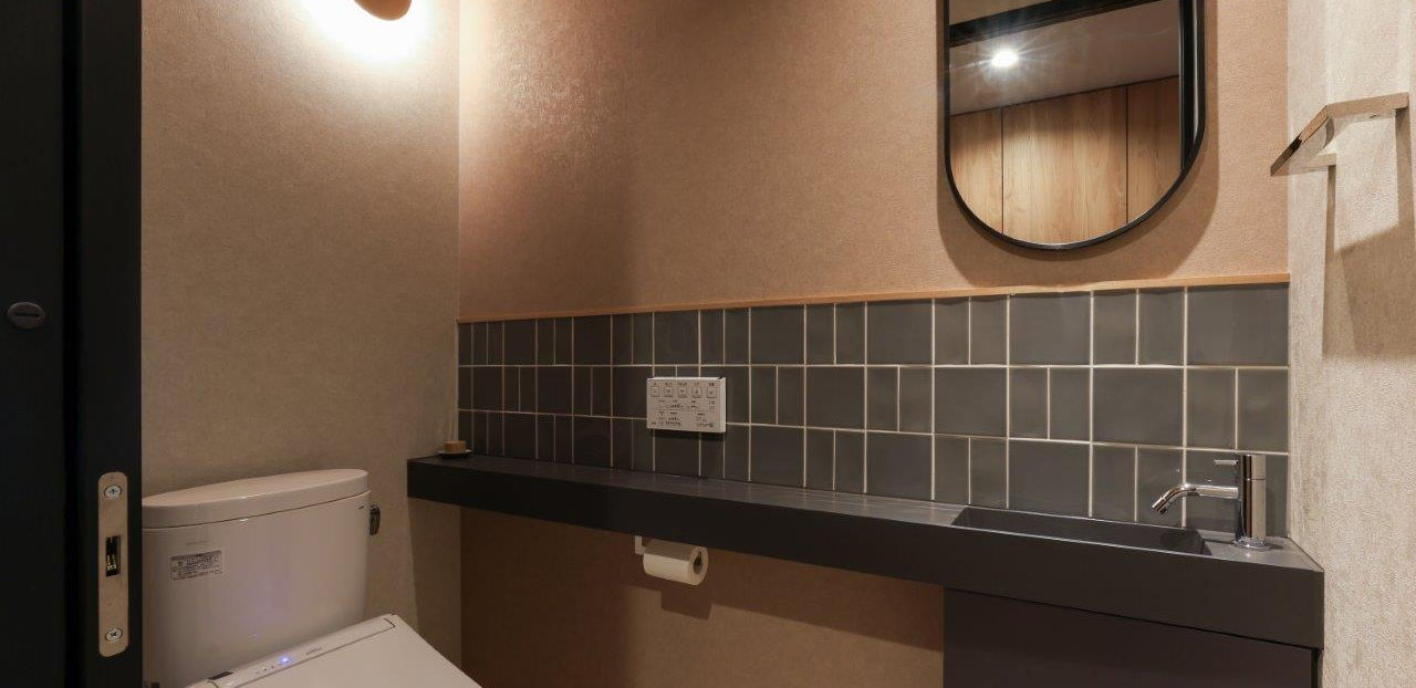 引き戸の広々としたトイレです。手洗いと大きな鏡があります。